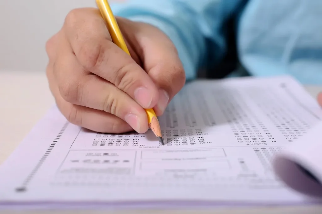 Bàn học có sách tiếng Anh và bút, minh hoạ việc chuẩn bị chứng minh trình độ tiếng Anh khi xin visa