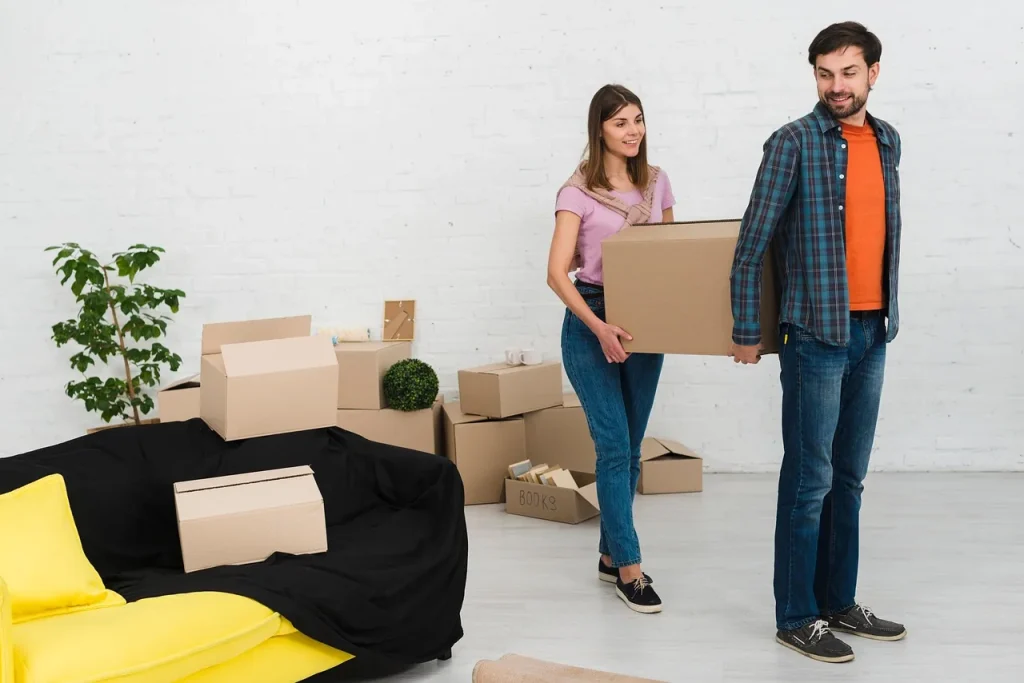 Hai người sắp xếp đồ đạc trong thùng, chuẩn bị chuyển sang nơi ở mới