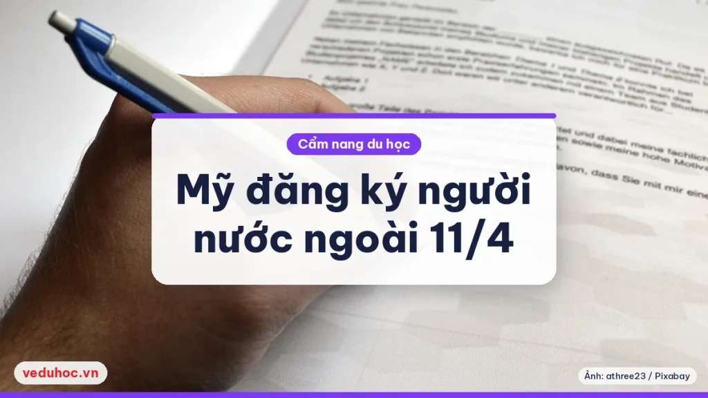 Bàn tay cầm bút ký lên tờ giấy mẫu trên mặt bàn gỗ sáng, minh hoạ thủ tục đăng ký giấy tờ cho người nước ngoài