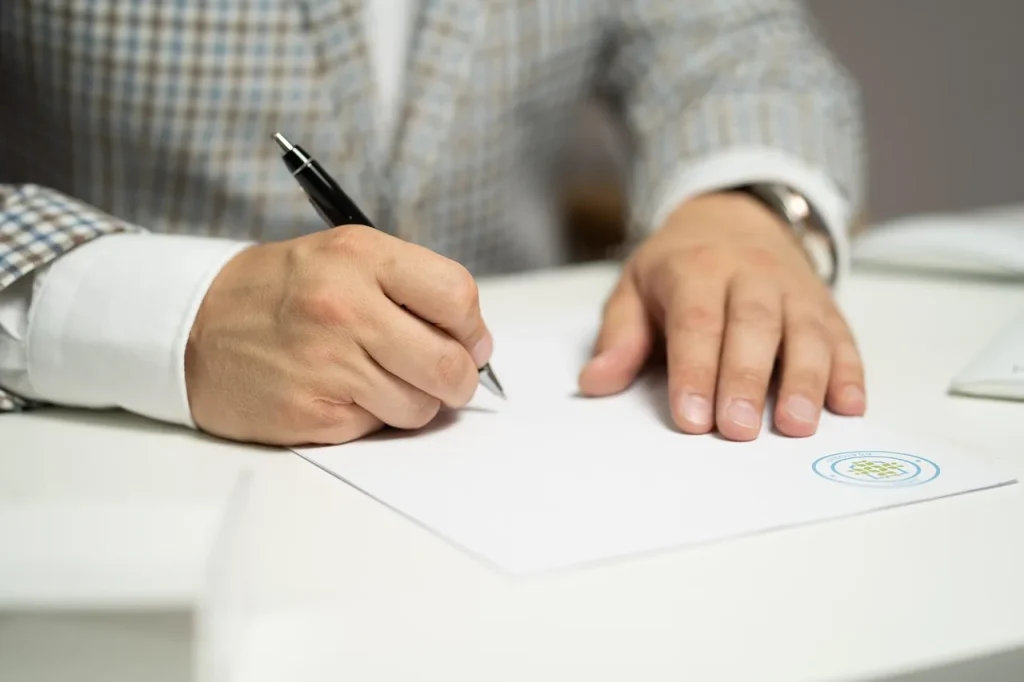 Giấy tờ và cây bút trên bàn, minh hoạ việc đọc kỹ điều luật về phí visa trước khi nộp hồ sơ