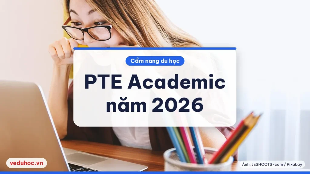 Cô gái cắn bút chì trước máy tính xách tay khi ôn thi PTE Academic