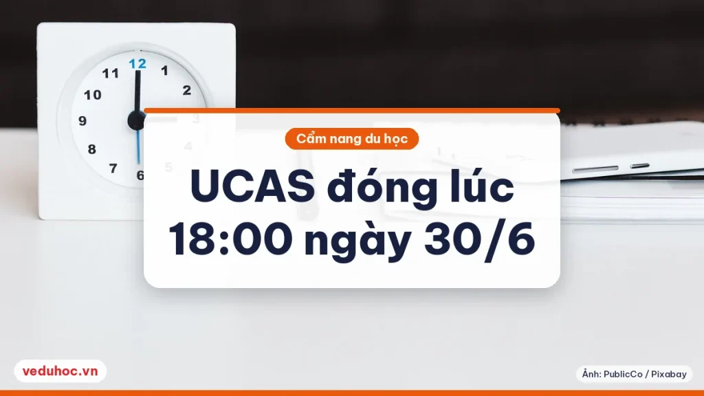 Chiếc đồng hồ để bàn màu trắng cạnh cây bút và sổ tay trên mặt bàn sáng, minh hoạ giờ chốt hồ sơ UCAS ngày 30/6